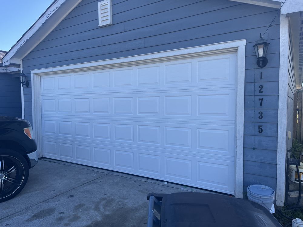 White double garage door on blue home